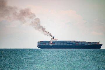 container ships in the sea have a lot of black smoke.