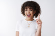 © Cookie Studio - Got idea. Excited creative young female coworker sharing thoughts raise index finger eureka gesture smiling broadly speak telling awesome suggestion found perfect solution, explain plan