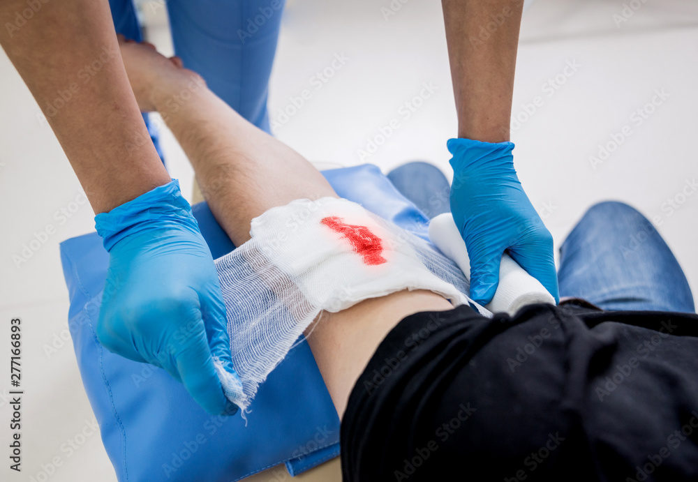 Nurse dressing wound for patient's hand with deep skin cutting. Stock Photo  | Adobe Stock