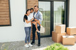 © Peakstock - Happy parents with daughter standing on backyard with cardboard boxes. buying an apartment.