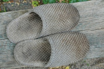 Wall Mural - two old gray dirty slipper stand on a wooden board