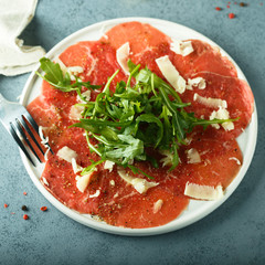 Poster - Homemade beef carpaccio with cheese and arugula