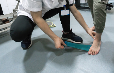 The doctor is rehabilitating the patient's legs