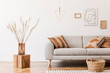 © FollowTheFlow - Modern boho interior of living room at cozy apartment with gray sofa, honey yellow pillows and plaid, mock up paintings, rattan basket and design personal accessories. Stylish home decor. Template.