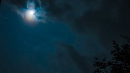 night sky and astronomy on blue background concept from full moon behind the cloud during watch spectacular winter solstice event in december of 2018