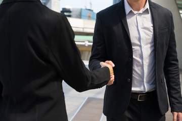 businessman shaking hands with businesswoman for demonstrating their agreement to sign contract between their companies. success, dealing, greeting and partner concept.