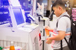 The boy is scanning the product at the automatic payment machine.  self service machine in modern supermarket, self-service pay point tills, self-checkout machine in hypermarket, Bangkok Thailand.