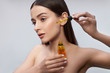© Yakobchuk Olena - Beautiful young woman applying vitamin serum on her face