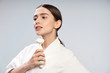 © Yakobchuk Olena - Attractive young woman in white bathrobe holding pore cleansing brush