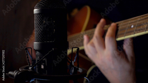 Pinturas sobre lienzo  musician playing guitar at studio . closeup