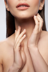 Wall Mural - Beautiful young female with natural makeup posing against light gray background