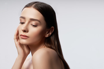 Wall Mural - Charming young lady with natural makeup keeping hand near head