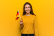 © Asier - Young european woman holding a germany flag happy, smiling and cheerful.