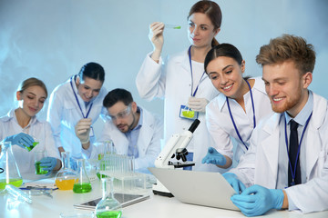 Poster - Group of scientists working in modern chemistry laboratory