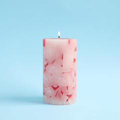 Alight scented wax candle on color background