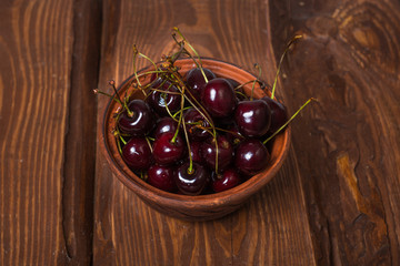 Poster - Fresh sweet sweet cherry in a plate on a wooden background.