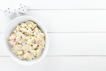 Fresh Homemade Vegetarian Potato Salad Made With Red Onion, Pickles, Mayonnaise And Mustard, Served In Bowl, Photographed With Copy Space Overhead On White Wood
