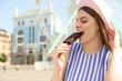 © New Africa - Young happy woman eating ice cream in amusement park. Space for text