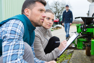 portrait of mechanics assessing agricultural equipment