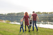© satura_ - Childhood and nature concept - Family walking by the water