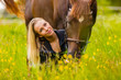 Close-up of woman feeding her arabian horse with snacks in idyllic meadow