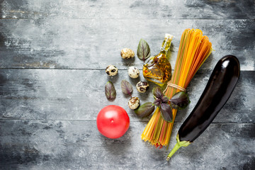 Multicolored spaghetti, vegetables, eggs and olive oil for cooking pasta.