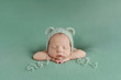 Sleeping newborn baby on a green background. Photoshoot for the newborn. A few days from birth.