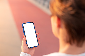 Woman uses a smartphone at sunset. Template, mockup.