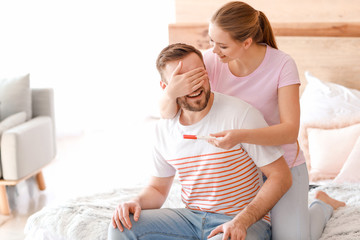 Wall Mural - Happy couple with pregnancy test at home