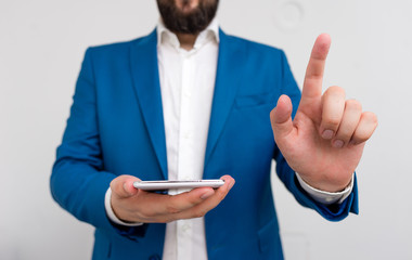 Businessman in the blue suite with lap top pointing with finger.