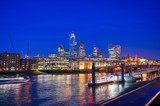 Fototapeta Mosty linowy / wiszący - A view of the London skyline across the River Thames in London, UK.