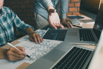 Two software developers are analyzing together about the code written into the program on the computer.