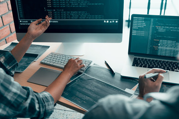 Working in the morning with businessmen are dipping coffee that works with software developers to analysis together the code written in the program on the computer.
