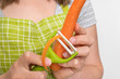 Woman peeling a carrot using food peeler