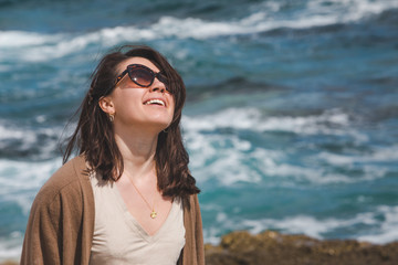 woman at sea beach enjoying power of nature. windy weather