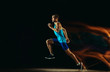 © master1305 - Professional male runner training isolated on black studio background in mixed light. Man in sportsuit practicing in run or jogging. Healthy lifestyle, sport, workout, motion and action concept.