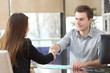© Antonioguillem - Serious businesspeople handshaking at office