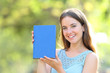 © Antonioguillem - Happy woman showing a blank book cover