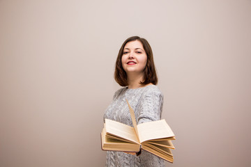 Wall Mural - Portrait of young brunette woman with book in her hand