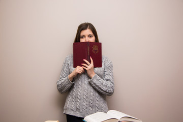 Wall Mural - Portrait of young brunette woman with book in her hand