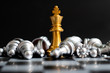 Leinwandbild Motiv Gold king chess piece win over lying down silver pawn on black background