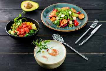 Canvas Print - lunch in a Thai restaurant, three dishes on the table soup with seafood, salad and fresh fish.