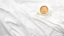 Morning flatlay in white bed. Coffee and morning routine. Copy space. Concept minimalism