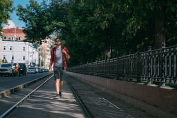 A man tourist walks through the streets with a backpack