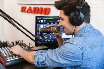 Wall Mural - Handsome happy young male radio host broadcasting