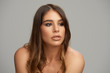 © chika_milan - Headshot of beautiful Caucasian brunette posing in front of grey background. Beauty photography.