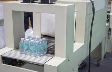 Wall Mural - Shrink film wrapping machine for package bottle of water. Food industry