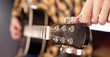 © SlayStorm - The young man tuning the electric guitar.