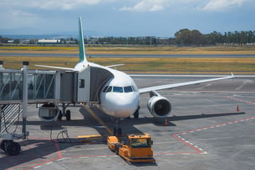 Aircraft in the day flight at the terminal before departure.