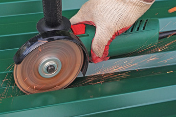   Cutting metal by electric wheel grinding. metal sawing close up hand tool